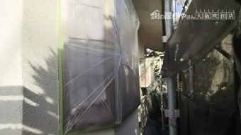 外壁にマスカーを使用し、塗装しない箇所を養生