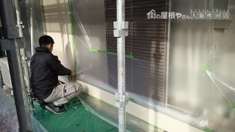 外壁にマスカーを使用し、塗装しない箇所を養生