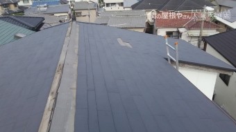 梯子でスレート屋根に上がって調査