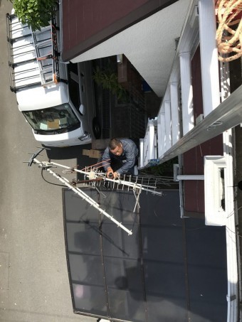 落下しかけたアンテナを撤去する作業員