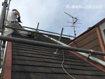 スレート屋根補修工事のために足場を組む職人