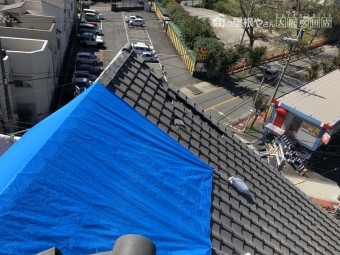 破損した瓦屋根にブルーシート応急処置