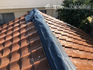 台風の強風で崩壊した棟を粘着シートでカバー
