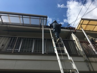 三連梯子で屋根に登っています。