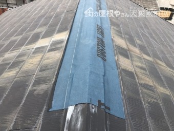 台風で被災したスレート屋根の大棟板金に防水シートで応急処置