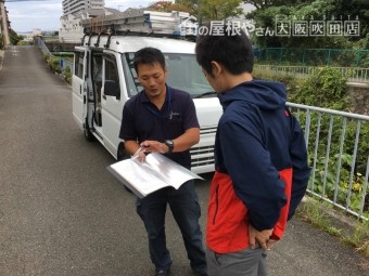 吹田市現場にて工事施工過程などをファイルを用いて説明させて頂いている様子
