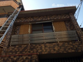 梯子で屋根調査に上がる職人