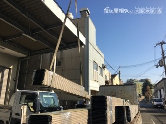 クレーンで持ち上げられる鋼板
