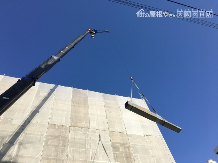 クレーンで持ち上げられる鋼板