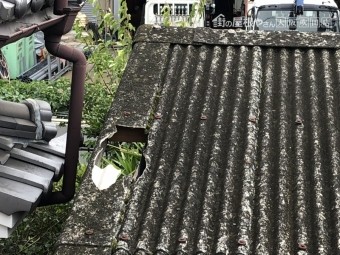 落下した鬼瓦が波板スレートを突き破った様子