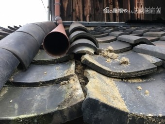 瓦の下の土が流れ出し歪みが生じている屋根。一部破損で落下の恐れがあり