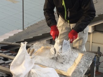 屋根の上で漆喰を練る職人