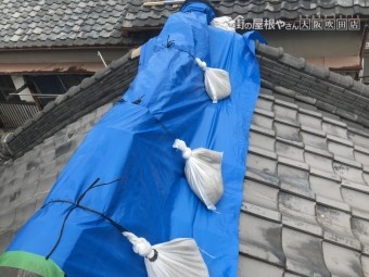 崩れた屋根をブルーシートで応急処置
