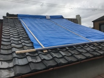 崩れた屋根をブルーシートで応急処置