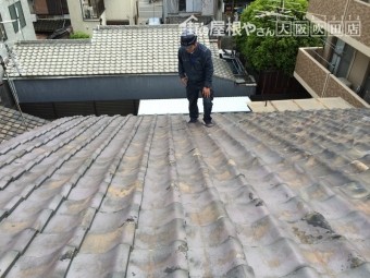 職人が瓦屋根に上がり屋根調査