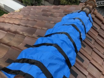 台風の被害を受けた屋根瓦にブルーシートで応急処置
