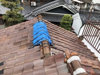 台風の被害を受けた屋根瓦にブルーシートで応急処置