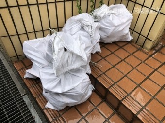 飛散した瓦を土嚢にまとめる
