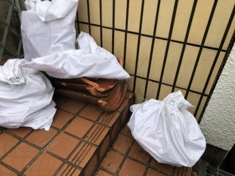 飛散した瓦を土嚢にまとめる