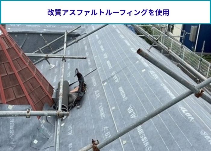 スレート屋根の上から防水シートを貼っている様子