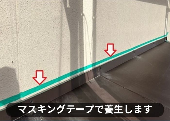 庇屋根の貼り替えで壁際にマスキングテープを貼っている様子
