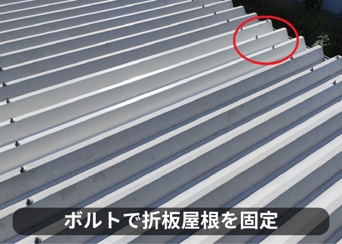 車庫の折板屋根をボルトで固定している様子