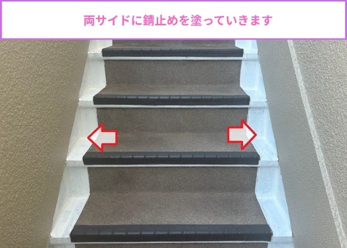 鉄骨階段の両サイドに錆止めを塗っている様子