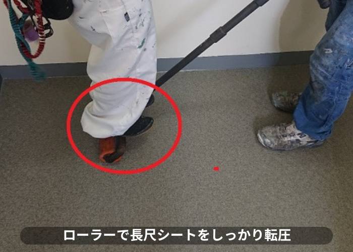 豊中市マンションの共用廊下で長尺シートを転圧している様子