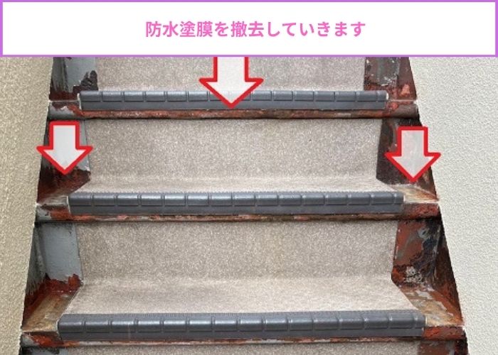 錆びた鉄骨階段の防水塗膜を撤去している様子