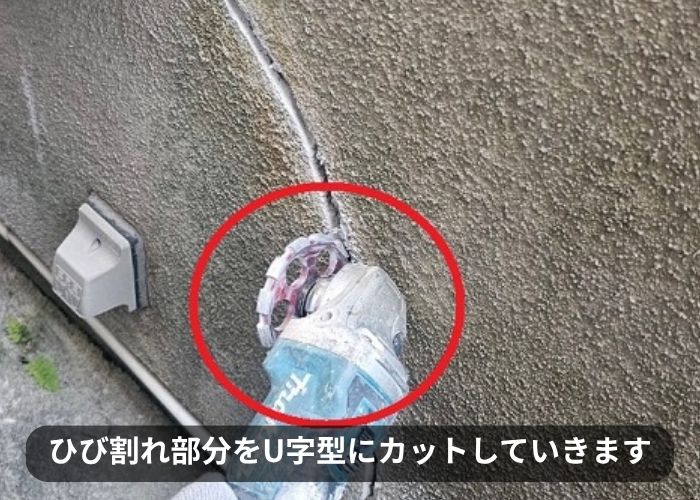 モルタル壁のひび割れ部分をU字型にカットしている様子