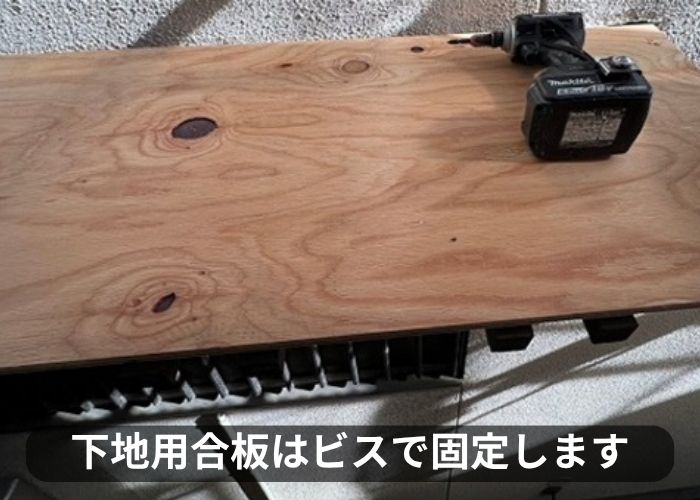 庇屋根の貼り替えで下地用合板をビスで固定している様子
