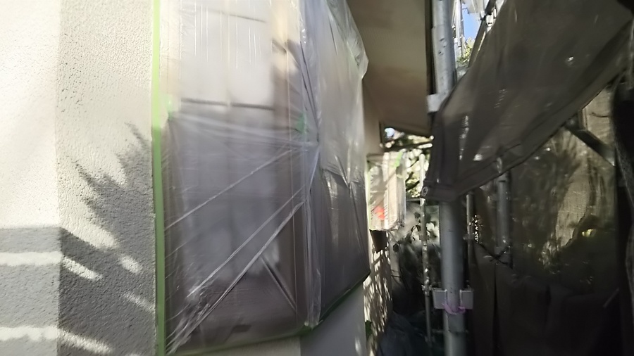 外壁にマスカーを使用し、塗装しない箇所を養生