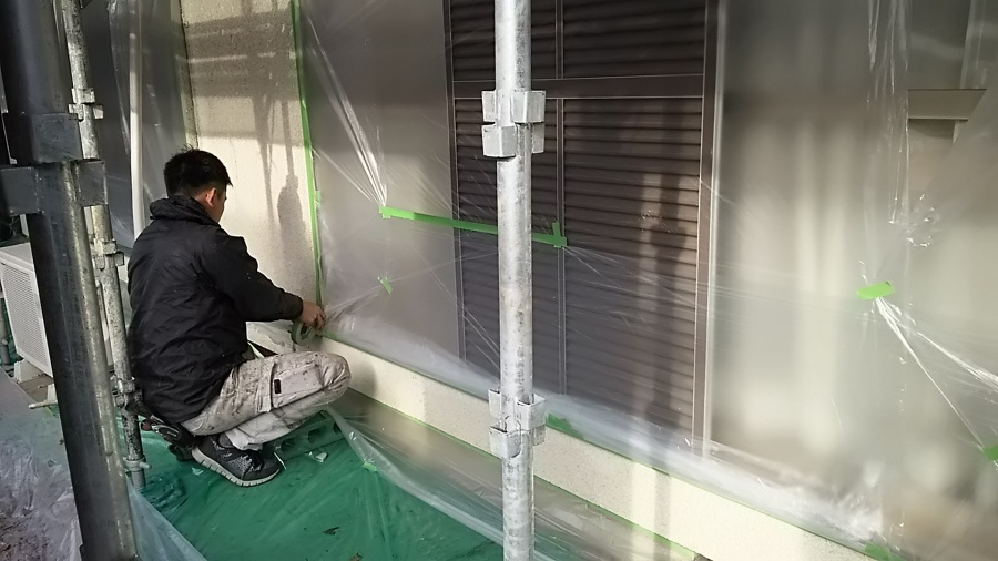 外壁にマスカーを使用し、塗装しない箇所を養生