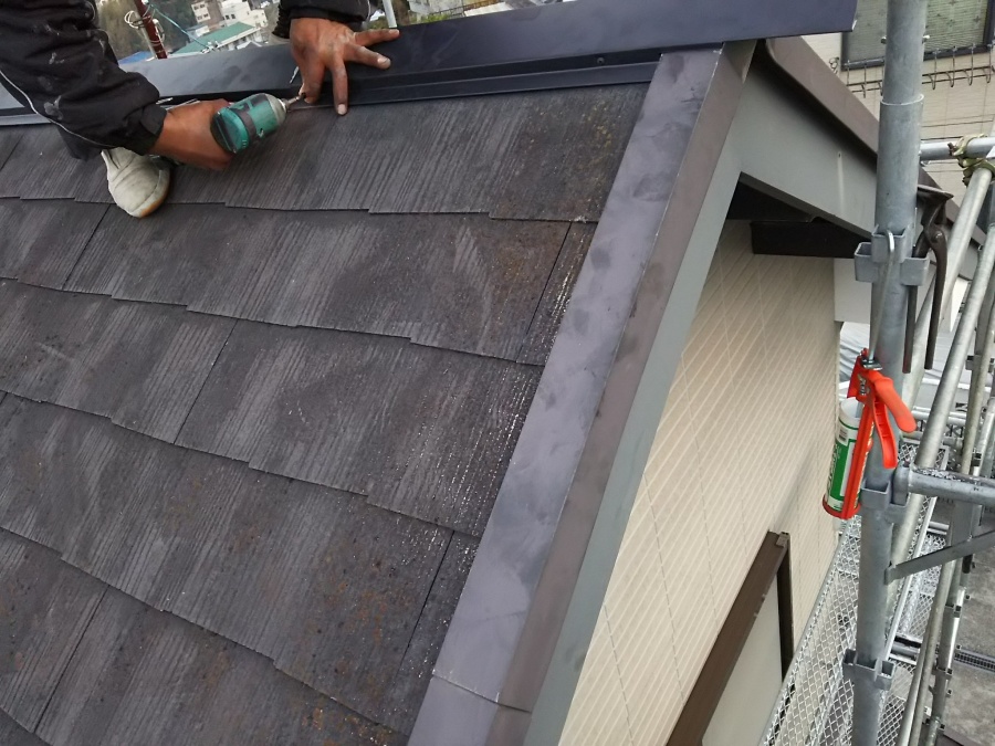 シルバーブラックの棟板金を横からビス打ち