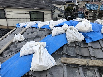 ブルーシートの横に土嚢袋を敷き詰め留めつける