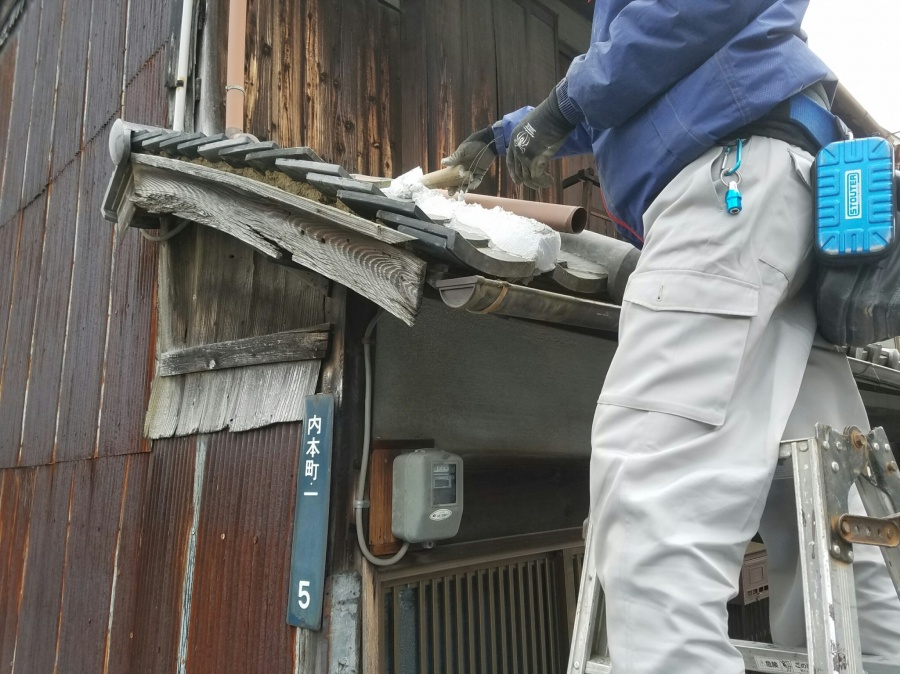 旧い瓦の屋根に新しくなんばんを敷いていく職人