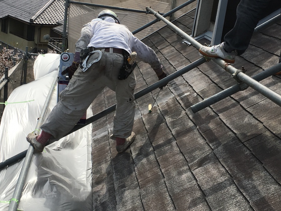 屋根下地塗料のニッペシリコンベスト強化シーラーを塗布する職人