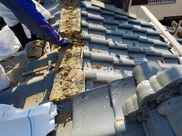 既存の棟の瓦とその下にある土を撤去している様子