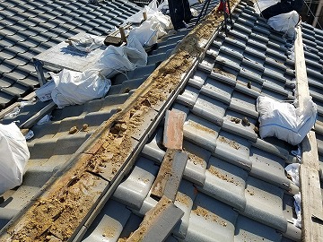 既存の棟の瓦とその下にある土を撤去している様子