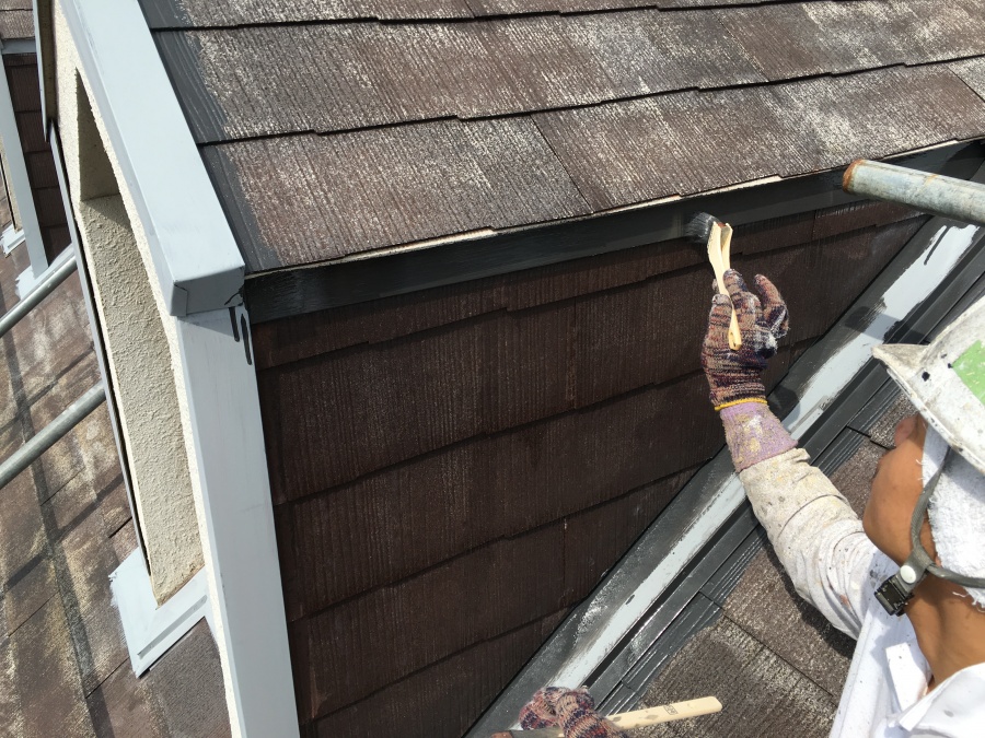 屋根板金に錆止め処理をした後塗装していく職人