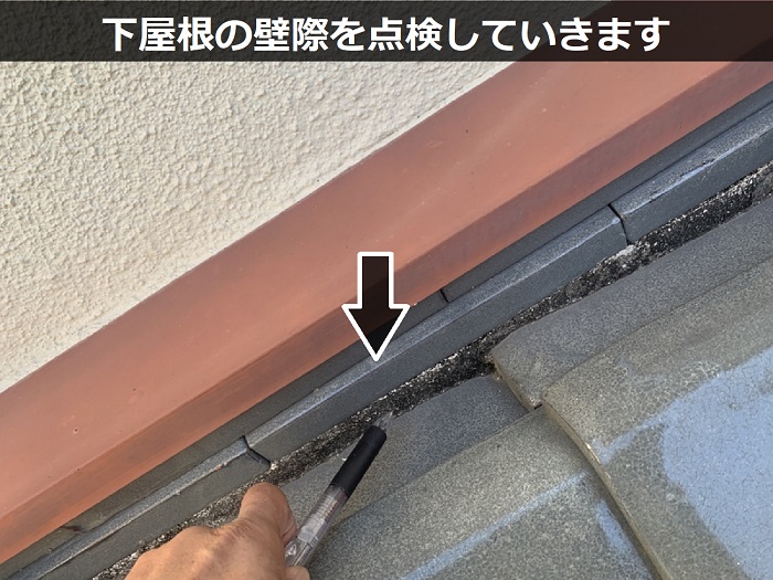 下屋根の壁際を調査している様子