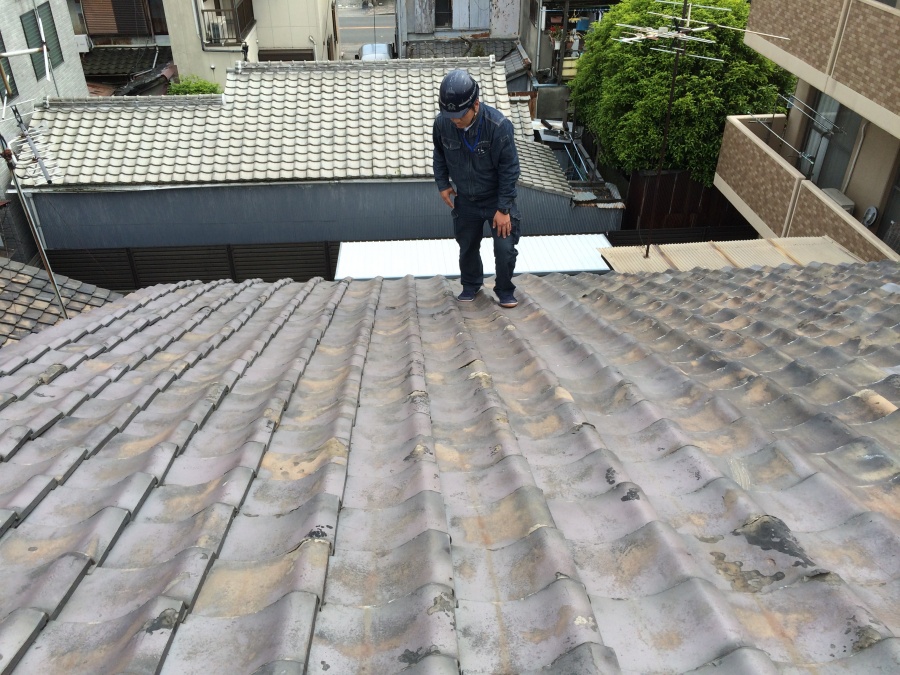職人が瓦屋根に上がり屋根調査