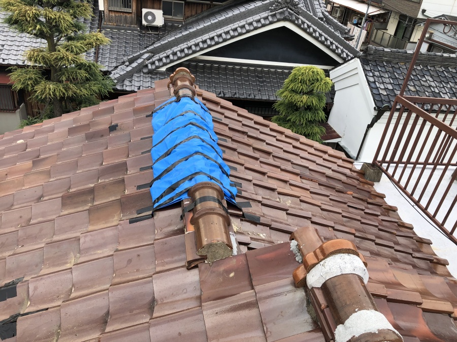 台風の被害を受けた屋根瓦にブルーシートで応急処置