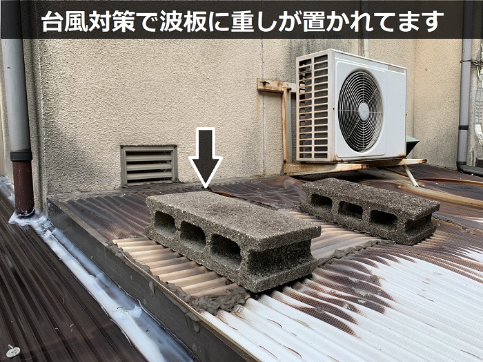 物置屋根に置かれたブロック