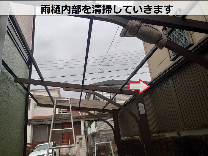 高槻市カーポート屋根の貼り替えを行う現場で雨樋内部を清掃