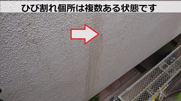 コンクリート造のアパートの外壁にひび割れが複数ある様子