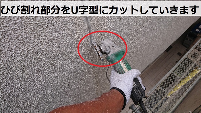 吹田市でアパートの外壁補修でひび割れをカットしている様子