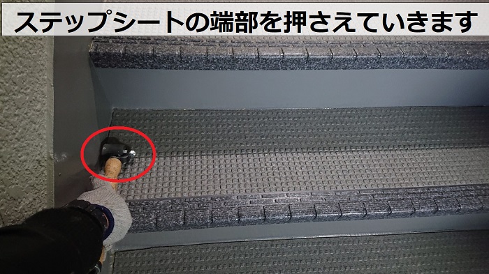 豊中市のハイツで共用階段のステップシートを転圧している様子