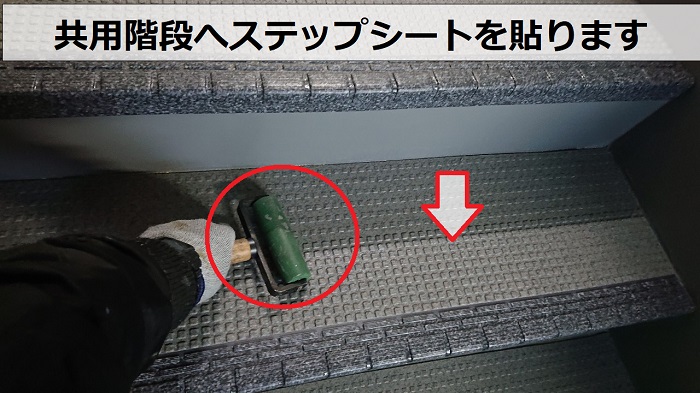 ハイツの共用階段へステップシートを貼っている様子