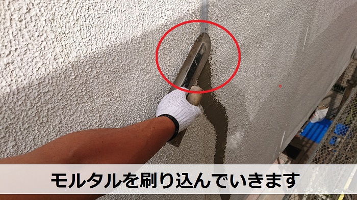 外壁補修でモルタルを刷り込んでいる様子